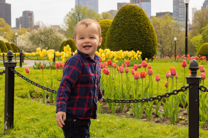 Micah se tient près de tulipes dans le jardin public de Boston