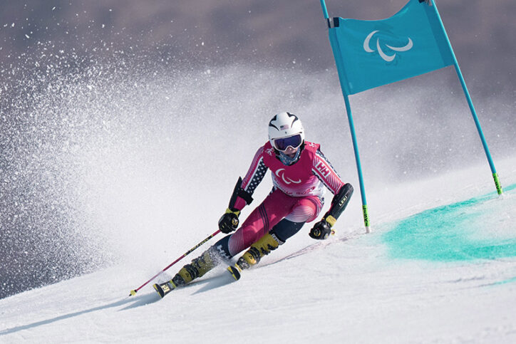 Thomas participe à des compétitions de ski alpin.  Il porte un équipement de ski et un casque.