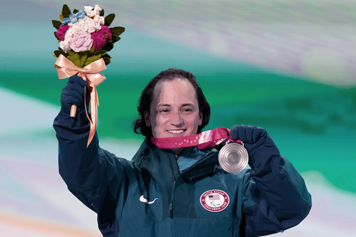 Thomas brandit un bouquet de fleurs et sa médaille d'argent aux Jeux paralympiques de Pékin.